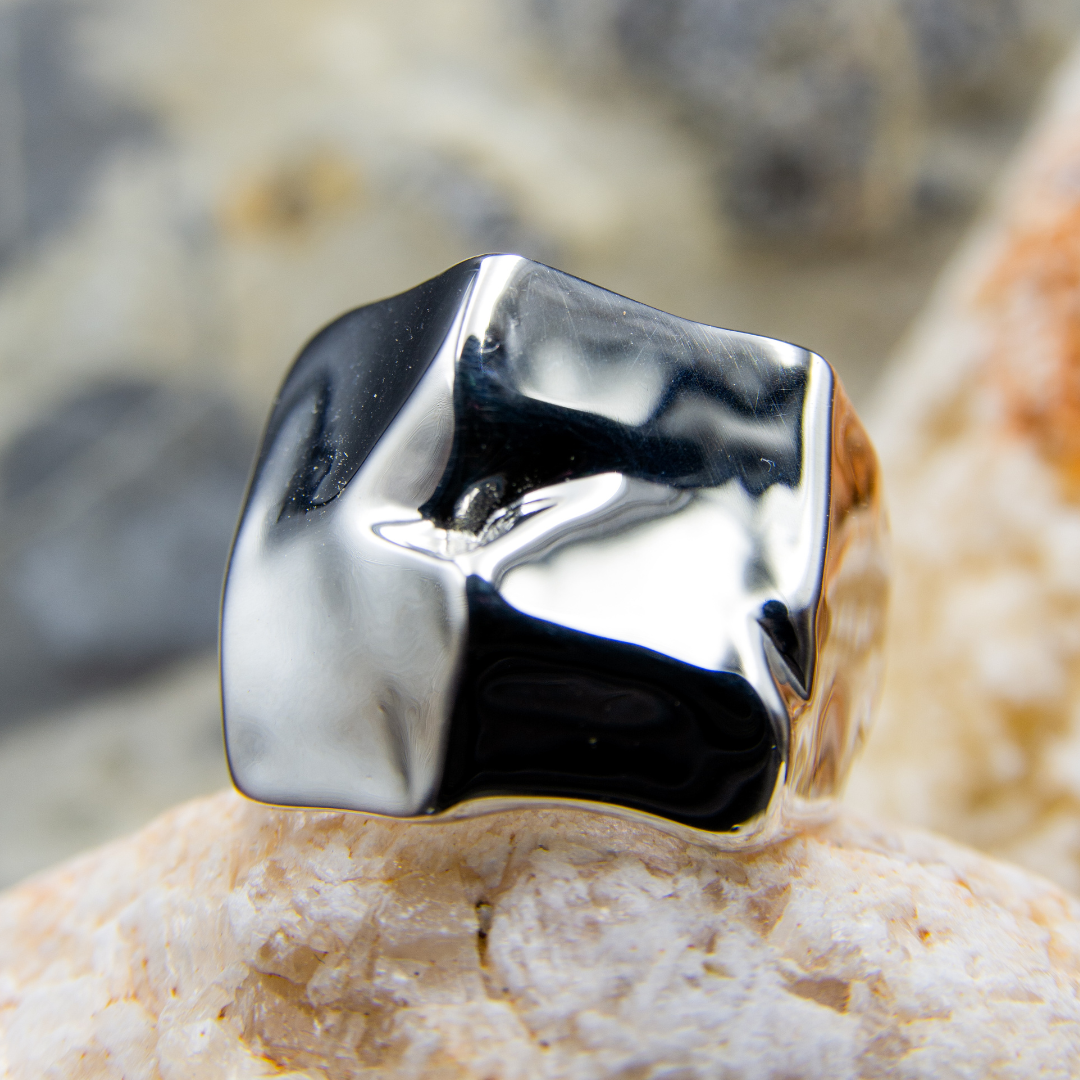 Silver ring with a unique design on a stone surface