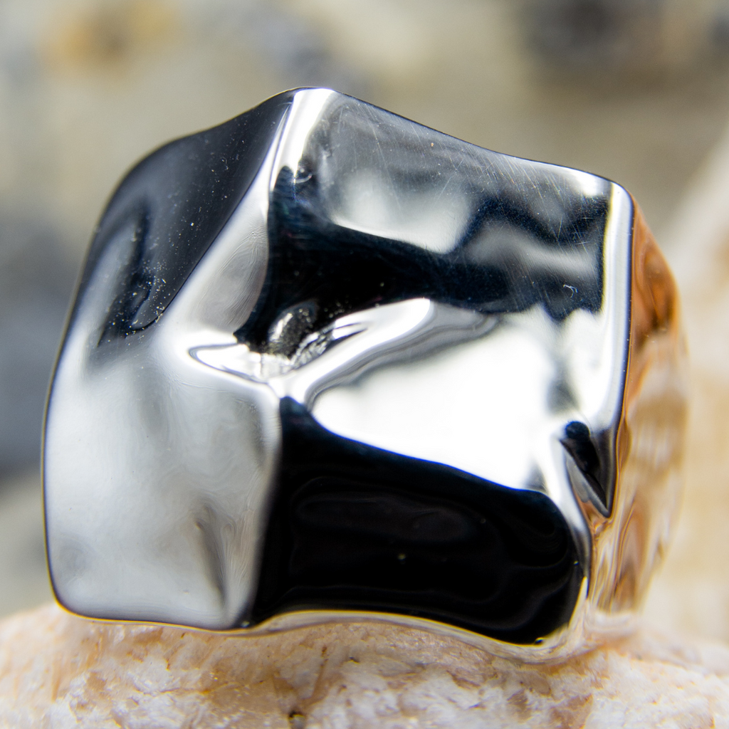 Silver ring with a unique design on a textured surface