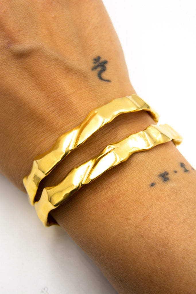 Gold Ourea cuff bracelet with a textured sculptural surface inspired by mountains and volcanic landscapes. 