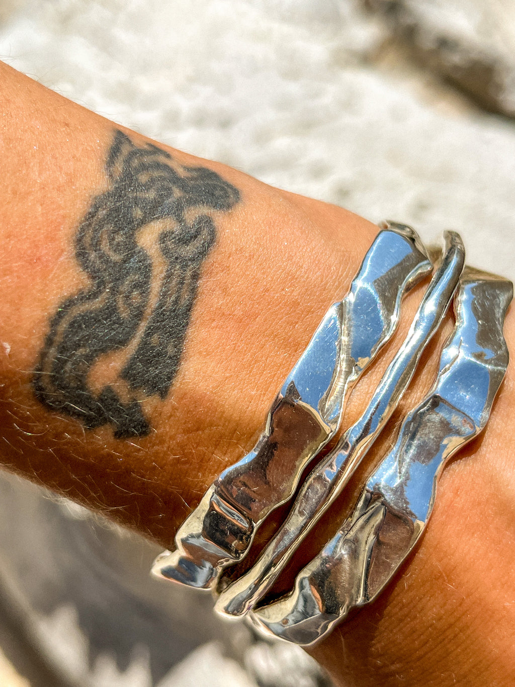 Silver Ourea cuff bracelet stack with a textured sculptural surface inspired by mountains and volcanic landscapes. 